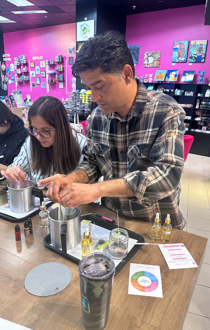 Guest pouring a custom Father's Day candle at Dad's Candle Bar in Pleasanton